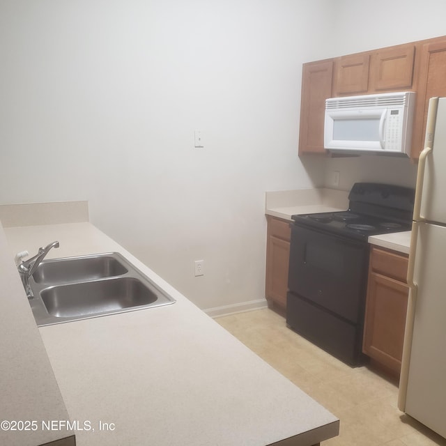 kitchen with white appliances, baseboards, brown cabinets, light countertops, and a sink