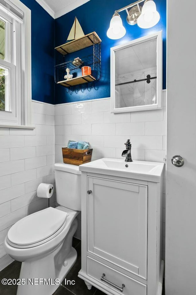 bathroom with vanity, tile walls, and toilet