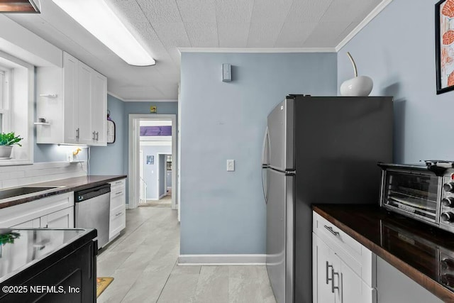 kitchen with crown molding, stainless steel appliances, and white cabinets