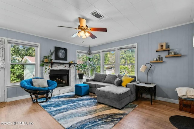 living room featuring ornamental molding, wood-type flooring, and a premium fireplace