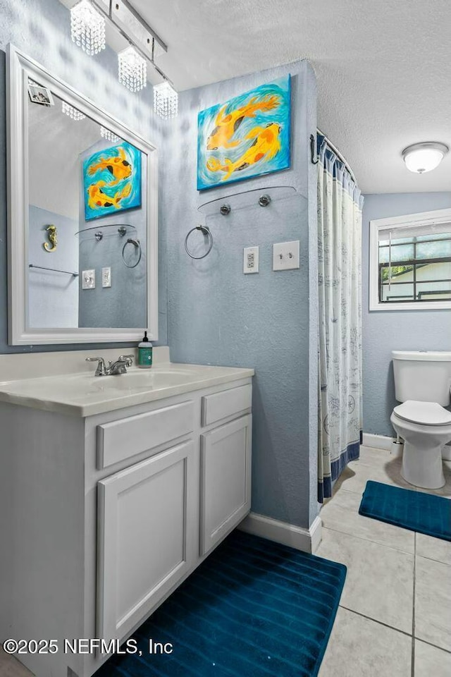 bathroom featuring tile patterned flooring, vanity, a textured ceiling, and toilet