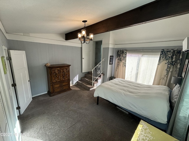 bedroom with dark colored carpet, a notable chandelier, and beam ceiling