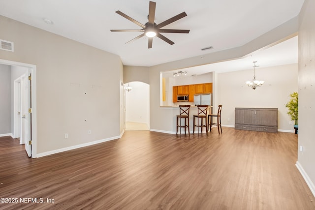 living room featuring wood-type flooring and ceiling fan with notable chandelier