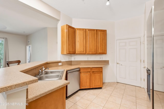 kitchen featuring sink, stainless steel dishwasher, light tile patterned floors, and kitchen peninsula