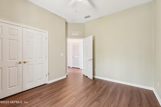 unfurnished bedroom with hardwood / wood-style flooring, ceiling fan, and a closet