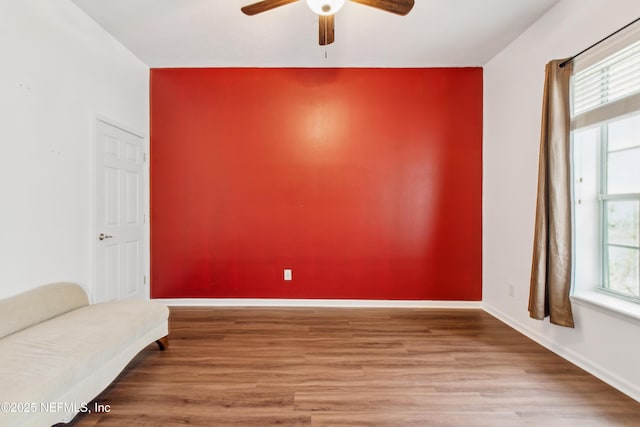 living area with ceiling fan, plenty of natural light, and hardwood / wood-style floors