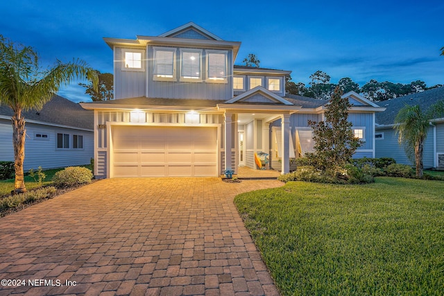 view of front of house featuring a garage and a yard