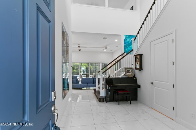 entrance foyer with ceiling fan and a high ceiling