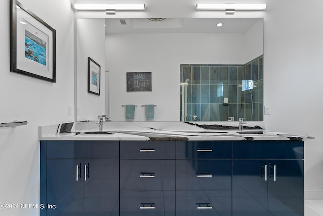 bathroom with tiled shower and vanity