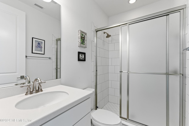 bathroom featuring vanity, toilet, and an enclosed shower