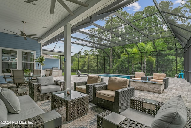 view of patio / terrace with ceiling fan, a lanai, and an outdoor living space with a fire pit