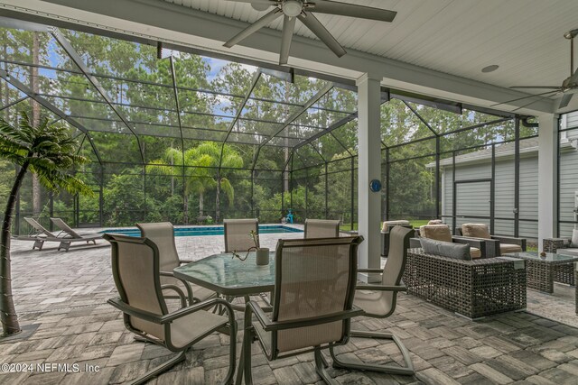 view of patio featuring an outdoor hangout area, ceiling fan, and glass enclosure