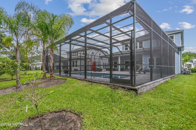 back of house with a lanai, a lawn, and a patio