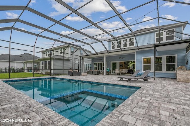 view of pool featuring a patio, an in ground hot tub, an outdoor hangout area, ceiling fan, and glass enclosure