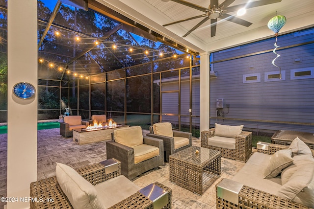 view of patio with ceiling fan, glass enclosure, and an outdoor living space with a fire pit