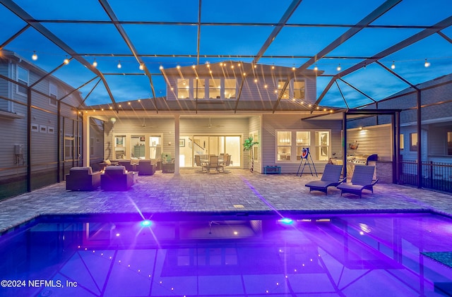 view of swimming pool with ceiling fan, outdoor lounge area, glass enclosure, and a patio area