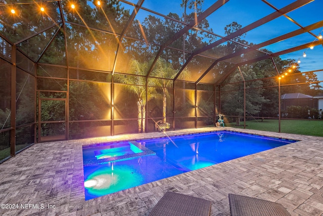 pool at dusk with a patio area, an in ground hot tub, and glass enclosure