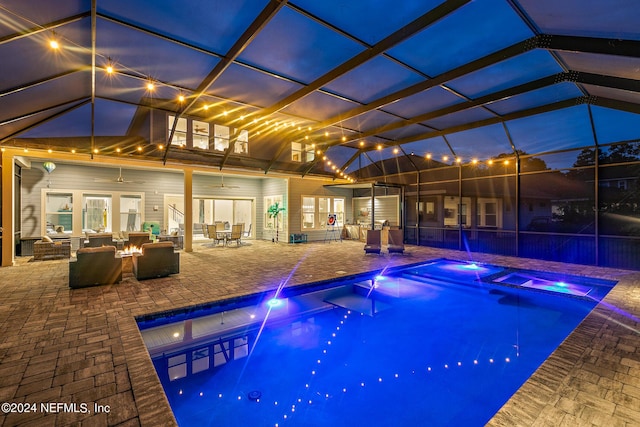 view of pool featuring a patio, an in ground hot tub, ceiling fan, an outdoor fire pit, and glass enclosure