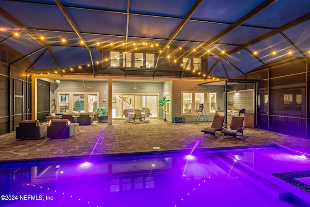 view of pool with outdoor lounge area, a patio area, ceiling fan, and a lanai