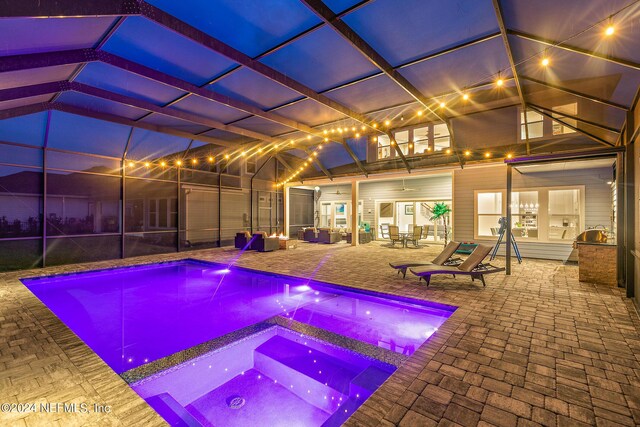 view of swimming pool featuring an in ground hot tub, a lanai, ceiling fan, and a patio