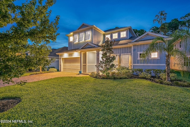 view of front of house featuring a garage and a lawn