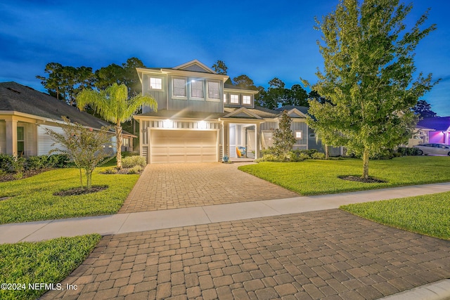 view of front of property featuring a garage and a yard