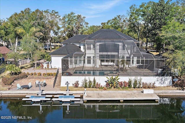 rear view of house featuring a water view, a patio area, a swimming pool, and glass enclosure