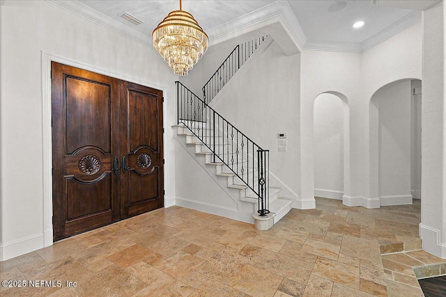 entrance foyer with an inviting chandelier and ornamental molding