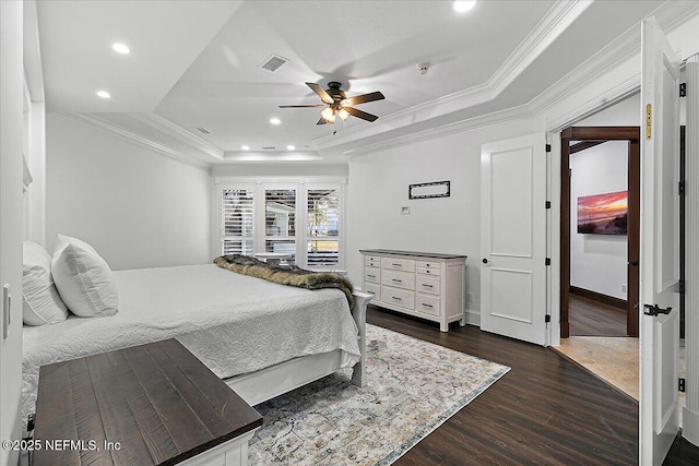 bedroom with a tray ceiling, ornamental molding, dark hardwood / wood-style floors, and ceiling fan