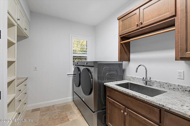 washroom featuring cabinets, sink, and washer and dryer