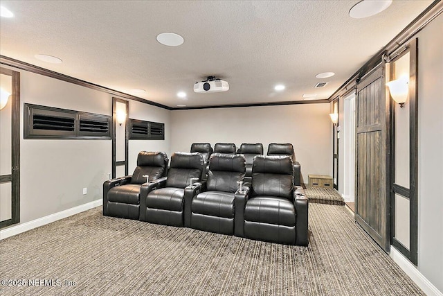 carpeted home theater room featuring ornamental molding, a barn door, and a textured ceiling