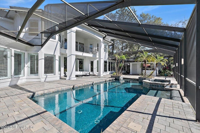 view of swimming pool with an in ground hot tub, a lanai, and a patio area