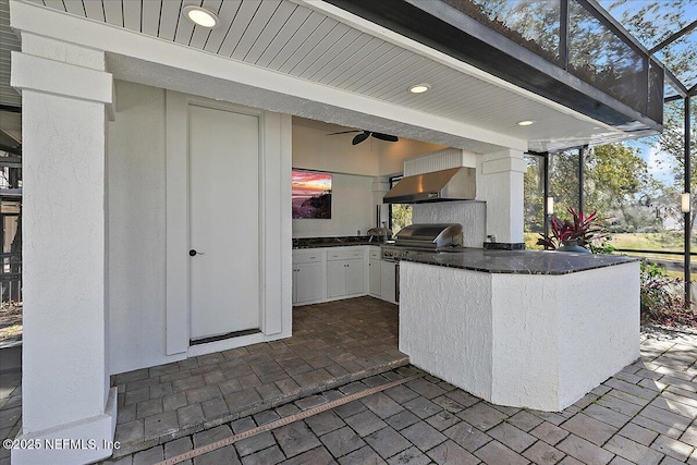 view of patio with an outdoor kitchen, a grill, and glass enclosure