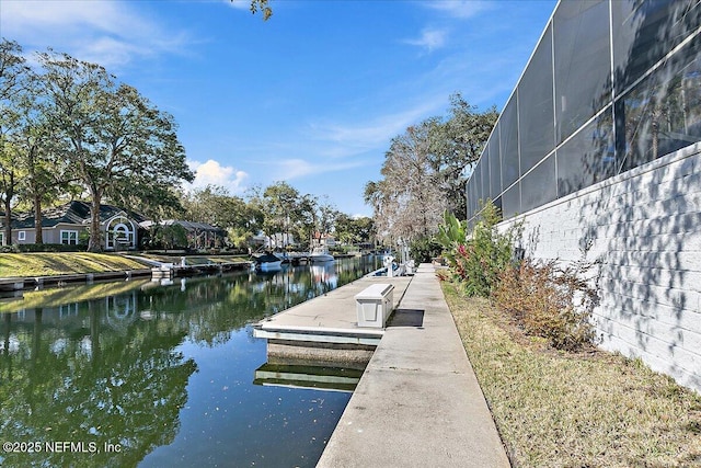 view of dock with a water view and glass enclosure