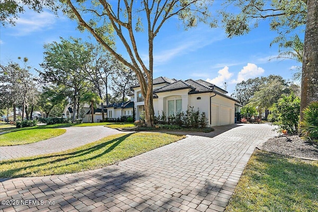 mediterranean / spanish-style home with a garage and a front yard