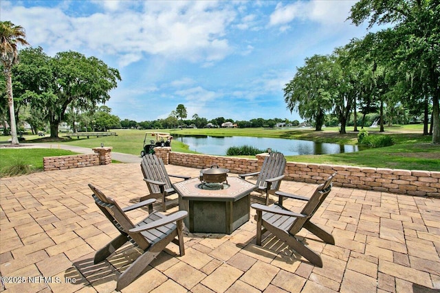 view of patio with an outdoor fire pit and a water view