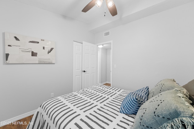 bedroom featuring hardwood / wood-style floors, ceiling fan, and a closet