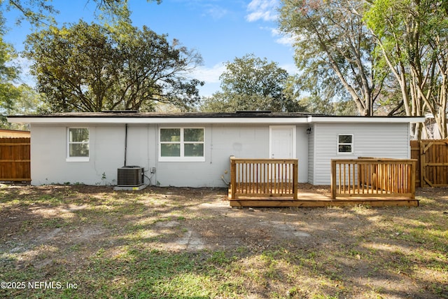 rear view of house featuring cooling unit and a wooden deck