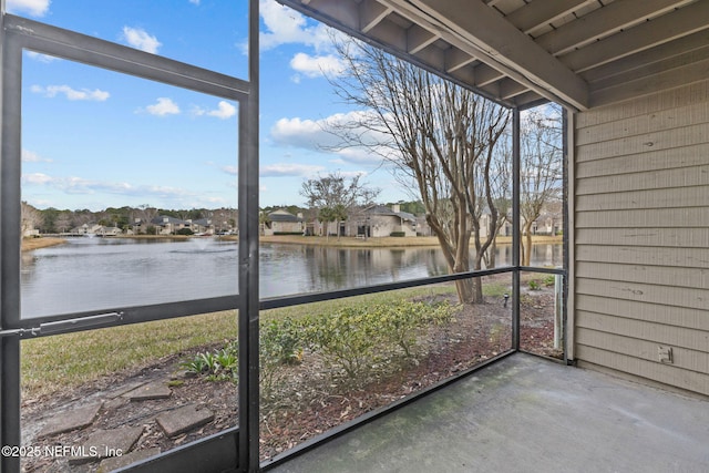 unfurnished sunroom featuring a water view