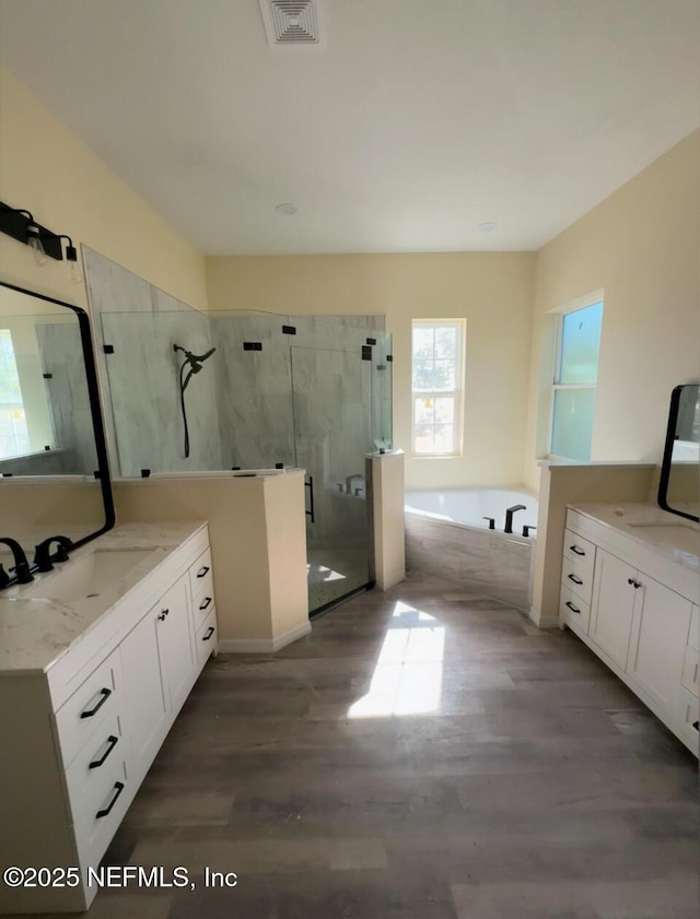 bathroom featuring plus walk in shower, wood-type flooring, and vanity