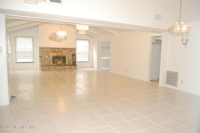 unfurnished living room featuring a healthy amount of sunlight, vaulted ceiling with beams, a high end fireplace, and a chandelier