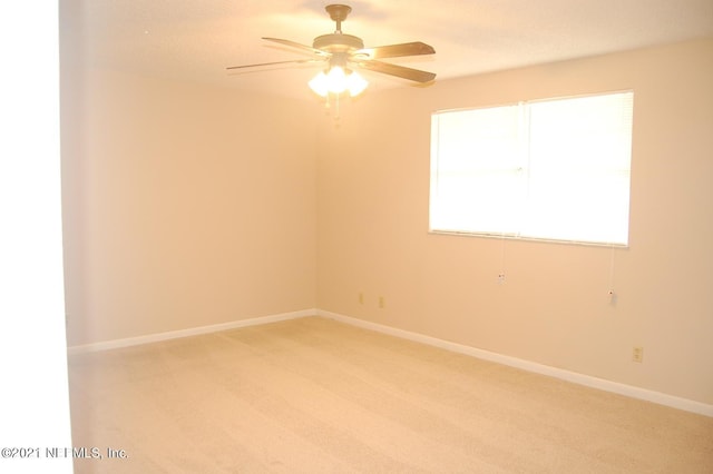 carpeted spare room with ceiling fan