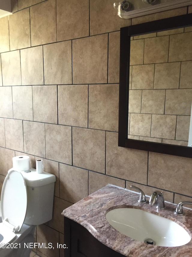 bathroom with tasteful backsplash, vanity, and toilet