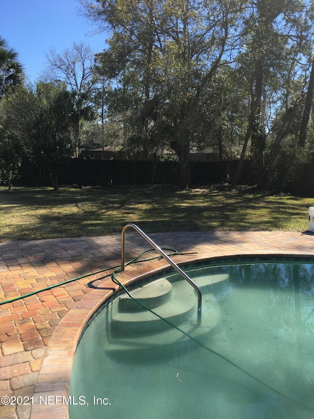 view of pool featuring a yard and a patio