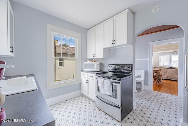 kitchen with stainless steel range with electric stovetop and white cabinetry