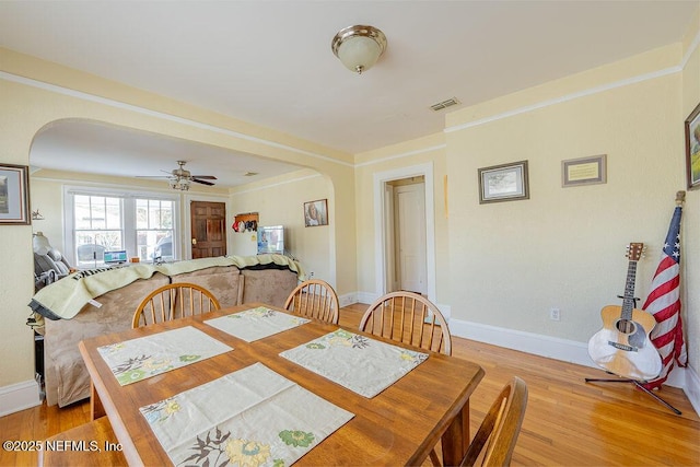 dining area featuring ornamental molding, ceiling fan, and light hardwood / wood-style flooring