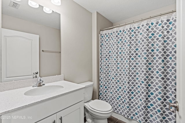 bathroom featuring vanity, a textured ceiling, and toilet