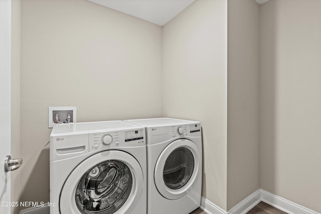 washroom featuring hardwood / wood-style flooring and washing machine and dryer