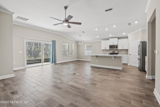 unfurnished living room with lofted ceiling, sink, crown molding, a textured ceiling, and ceiling fan with notable chandelier