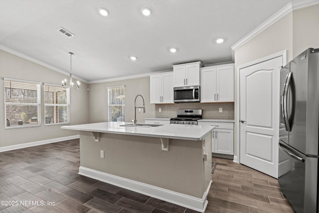 kitchen with sink, appliances with stainless steel finishes, a kitchen island with sink, white cabinetry, and hanging light fixtures